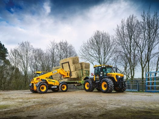 JCB Teleskoplader ladet auf den Traktor Stroh auf