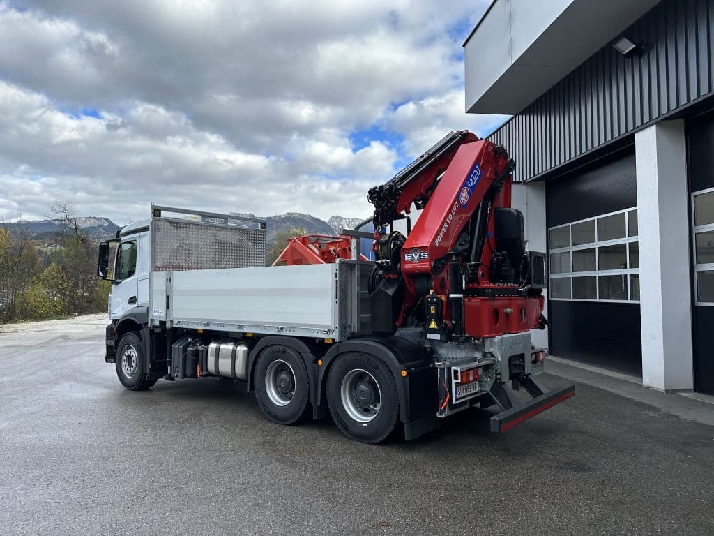 LKW mit aufgerichtetem rotem HMF-Ladekran